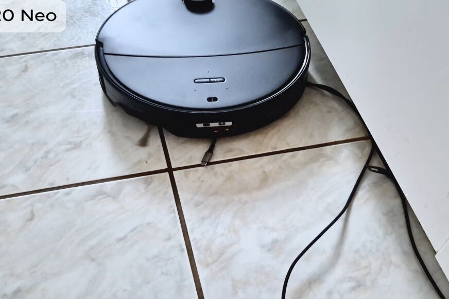 Roborock Saros 20 Neo fährt auf ein Ladekabel auf dem Boden zu